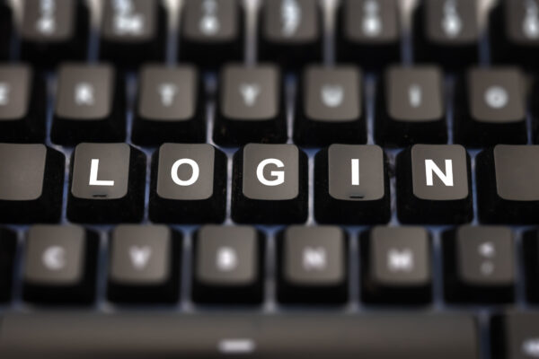 Login online concept. Login word written on keypad. Black keys with white letters message for identification and access on pc keyboard. Blur buttons background.